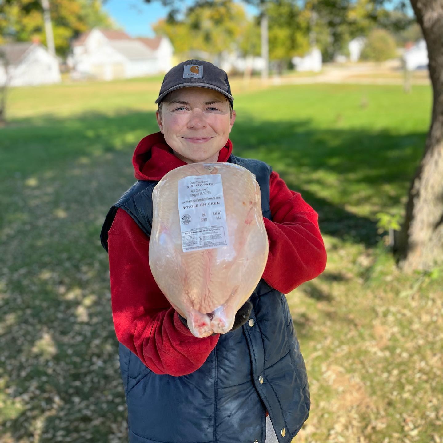 A women holding a large frozen chicken