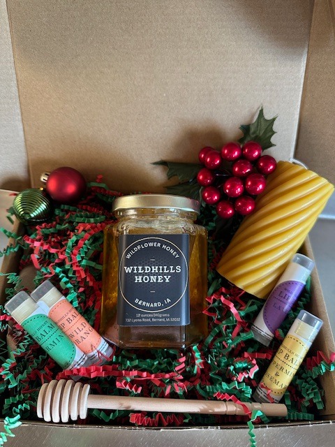 A gift box from Wildhills Honey features, beeswax candles, and lip balm.