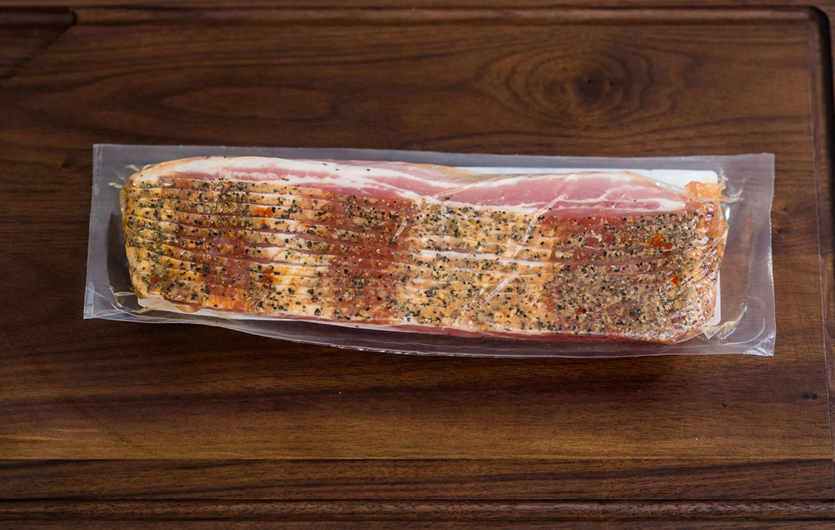 A package of bacon is wrapped and ready for purchase.