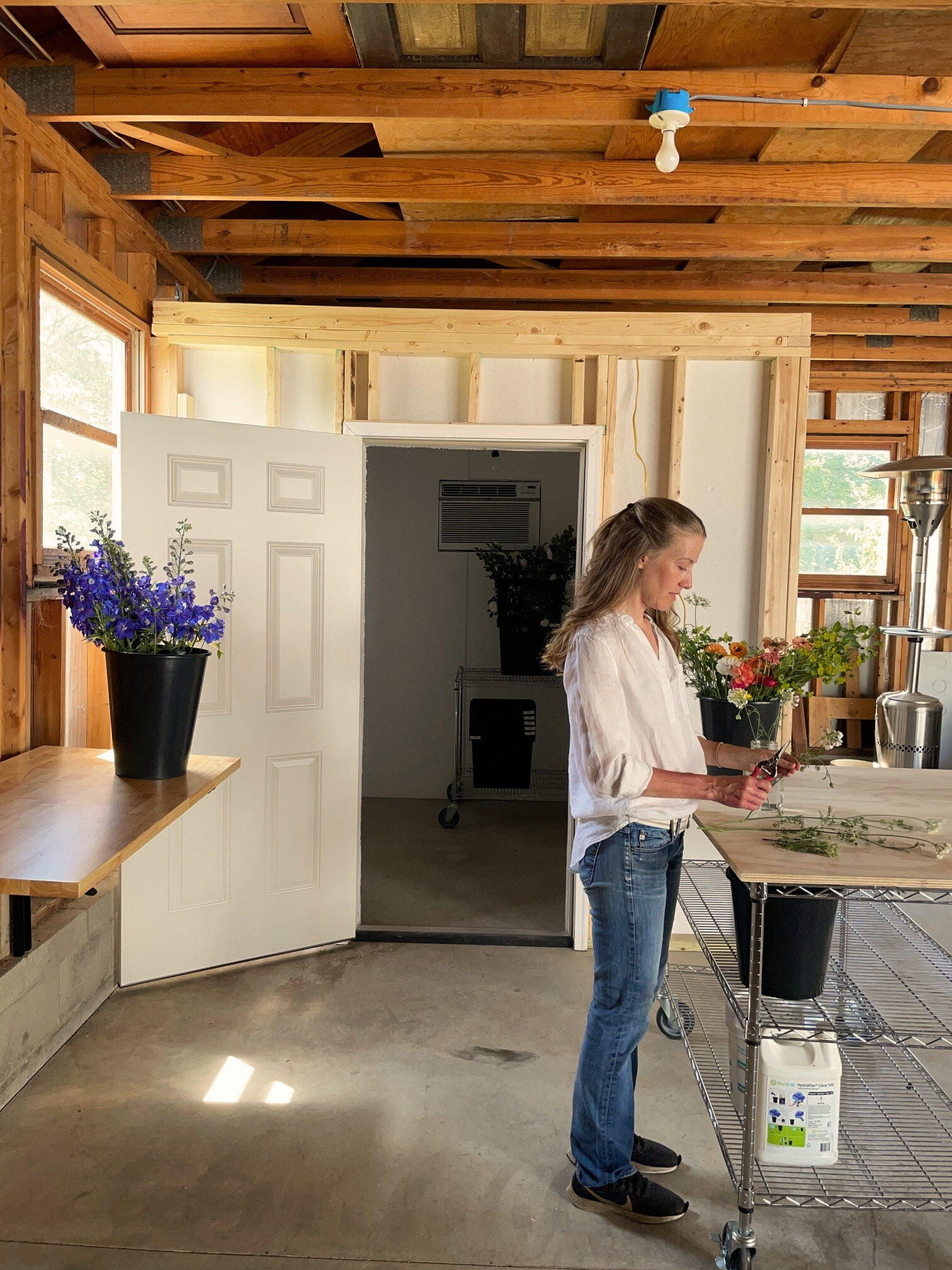 Lacey stands in her new space working on flower arrangements