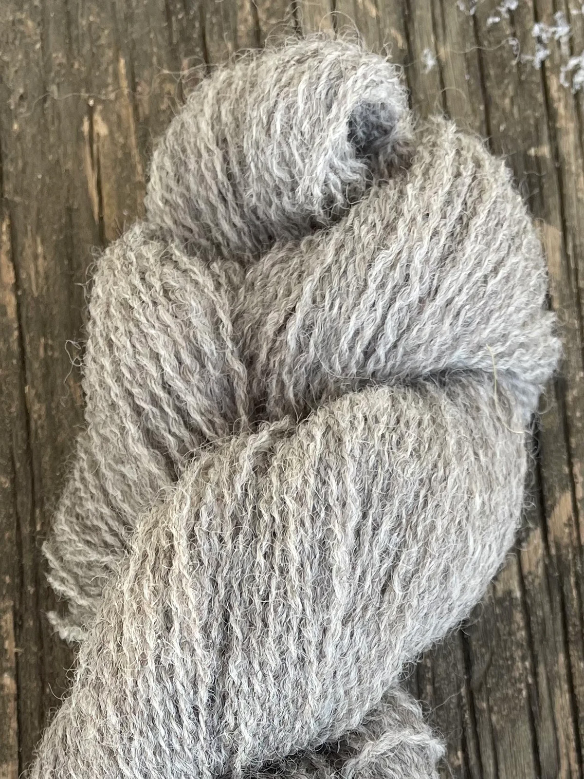 A skein of grey yarn is ready to purchase.