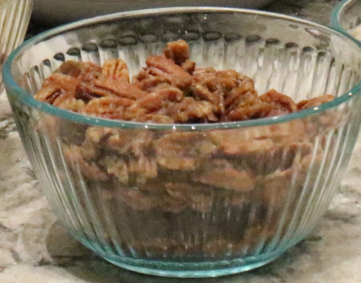 A bowl of candied pecans sits ready for a salad.