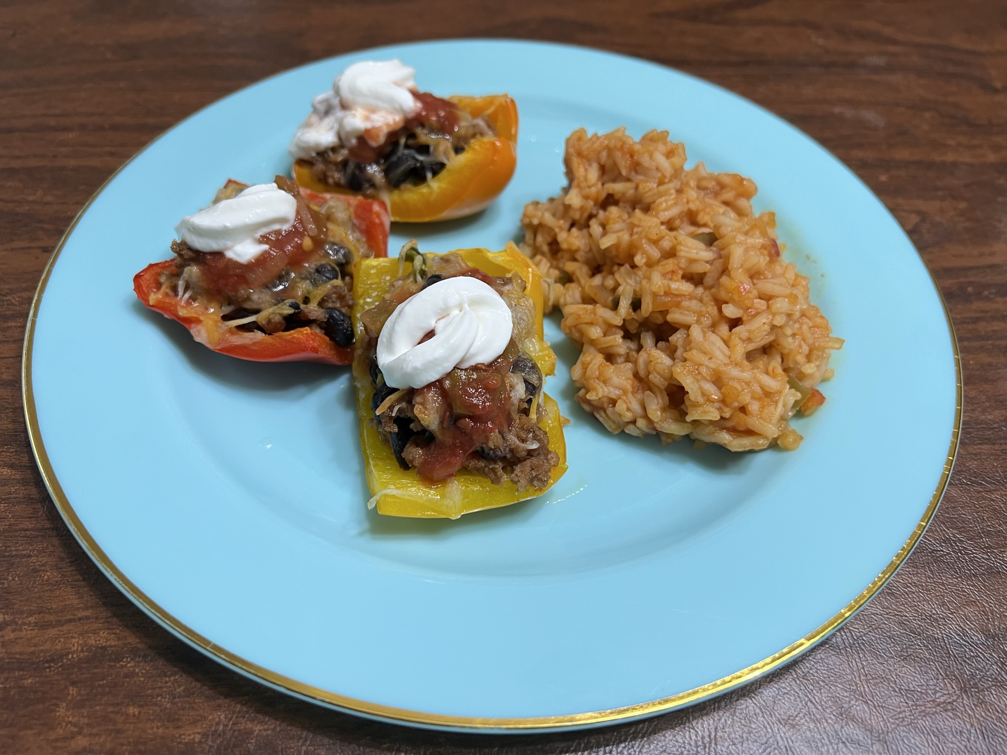 Bell Pepper pieces stuffed with ground turkey sit next to a pile of Mexican rice.