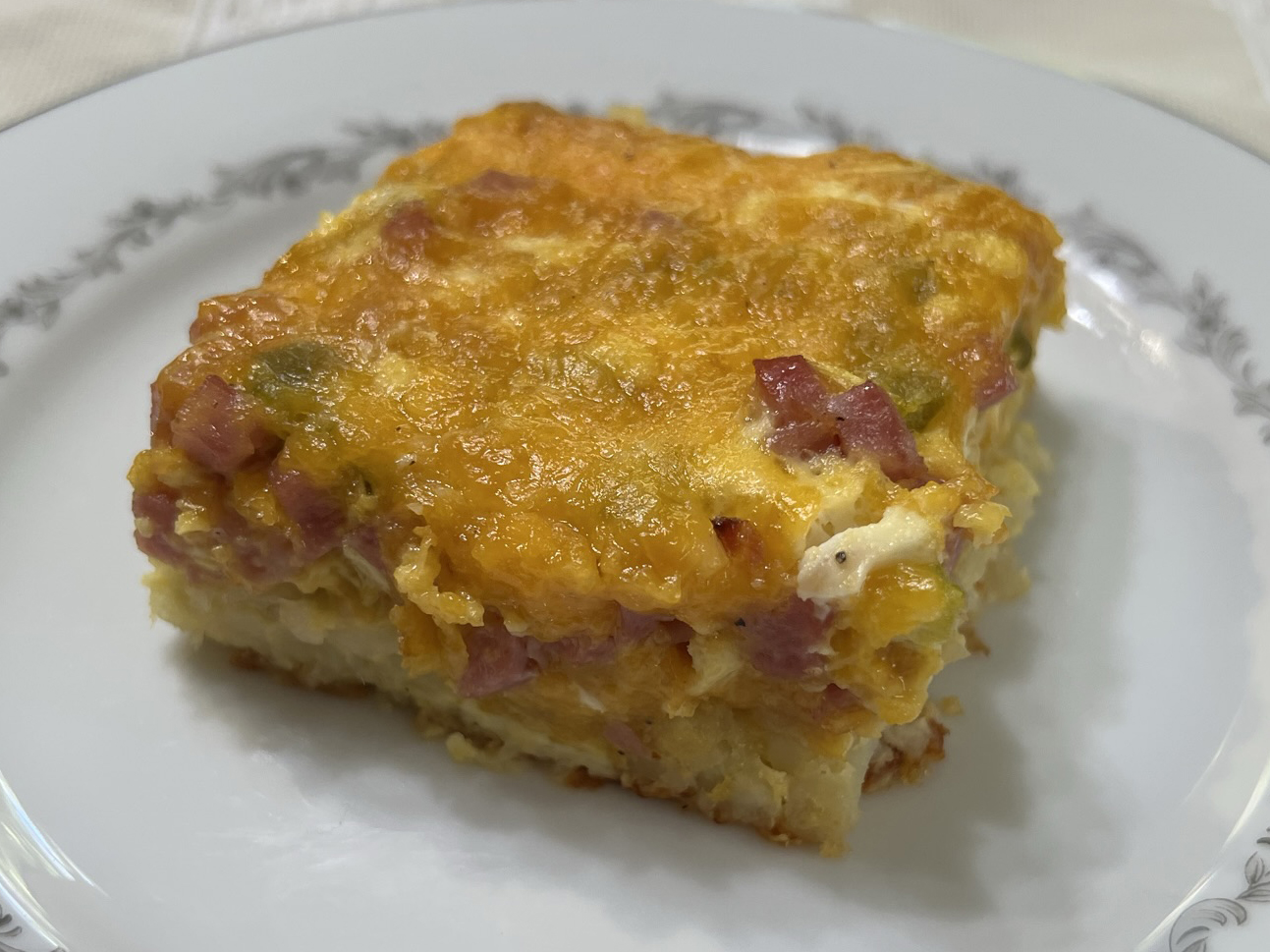 A piece of Wake Up Breakfast Casserole seats ready to eat.