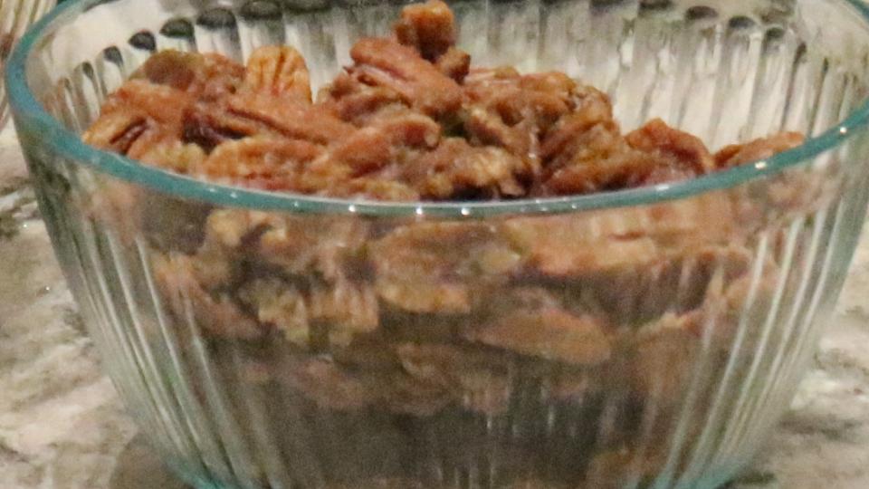 A bowl of candied pecans sits ready for a salad.