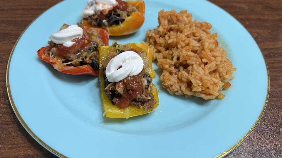 Bell Pepper pieces stuffed with ground turkey sit next to a pile of Mexican rice.
