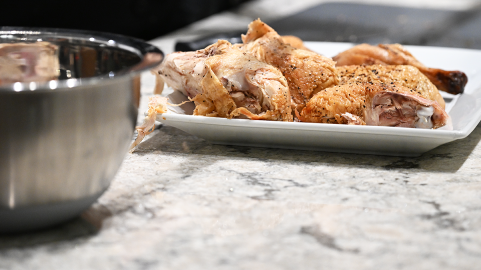 A chicken is being broken down and the pieces are on a page.