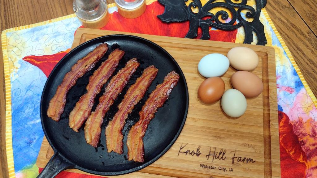 Cooked Bacon from our Certified Organic Berkshire-cross pigs on a cast iron skillet. 