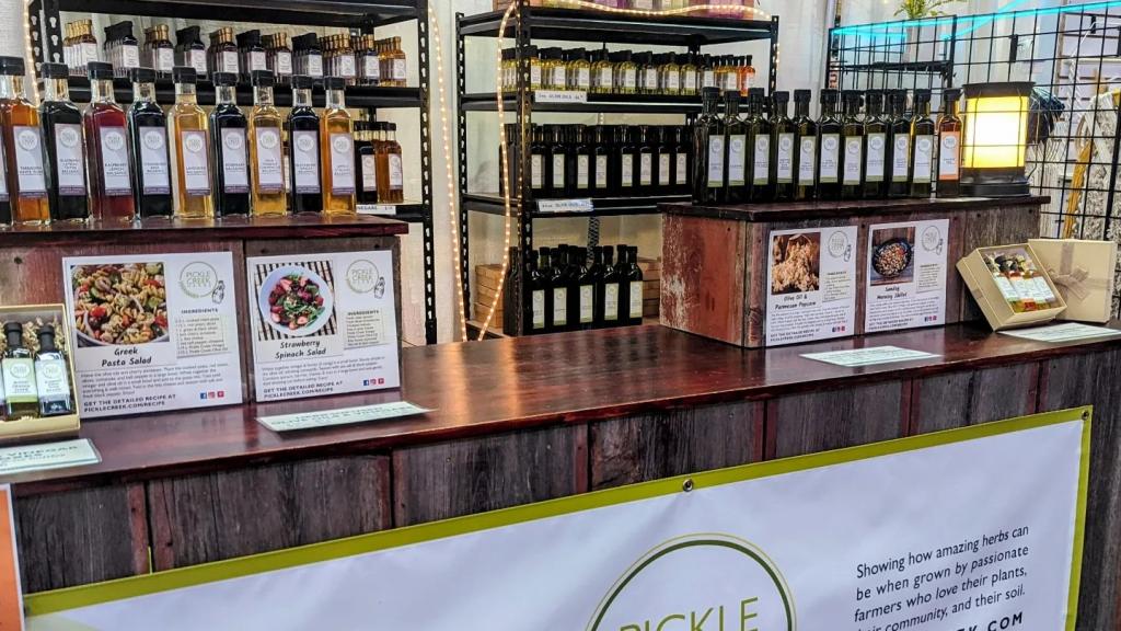 display of many products from Pickle Creek Herbs including oils, vinegars, soaps, lip balms and more