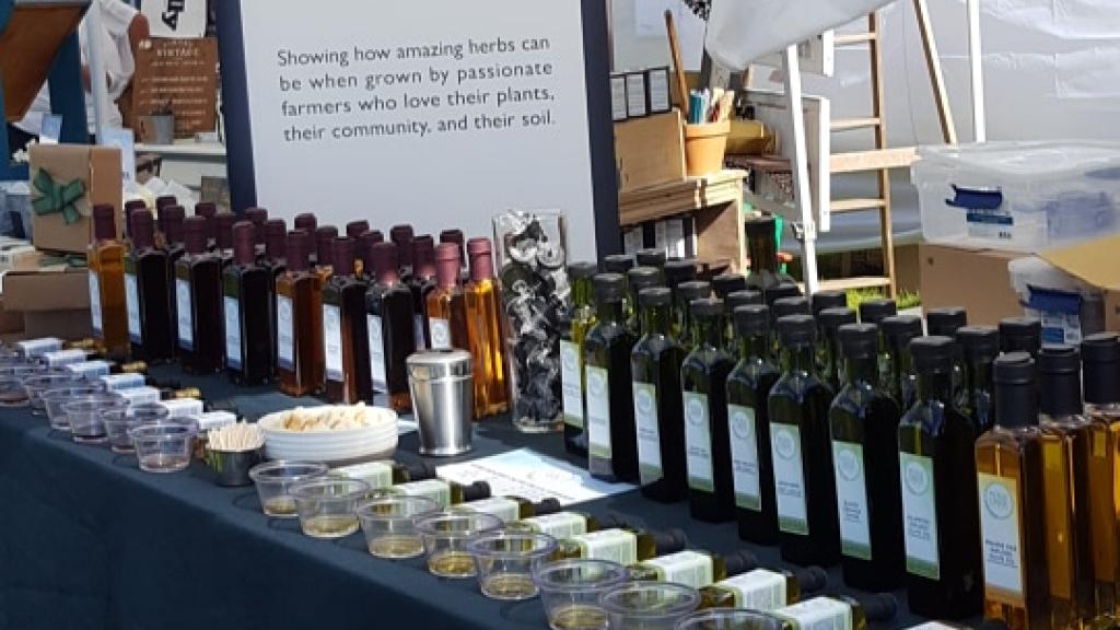 Display of many infused oils and vinegar products from Pickle Creek Herbs